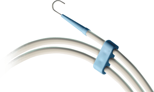Guidewire coiled in a circular dispenser tube held by a blue clip connector, with a J-tip at the end.